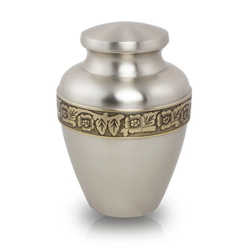 A brass cremation urn with a floral band accent, hand etched by artisans.