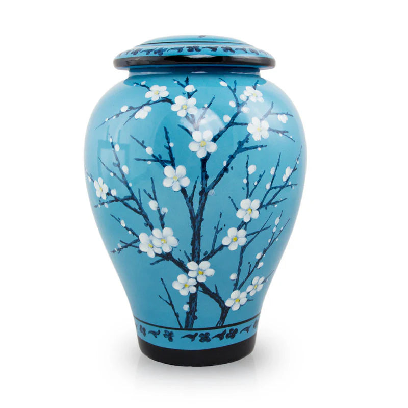 A ceramic cremation urn with a blue background and white floral patterns.