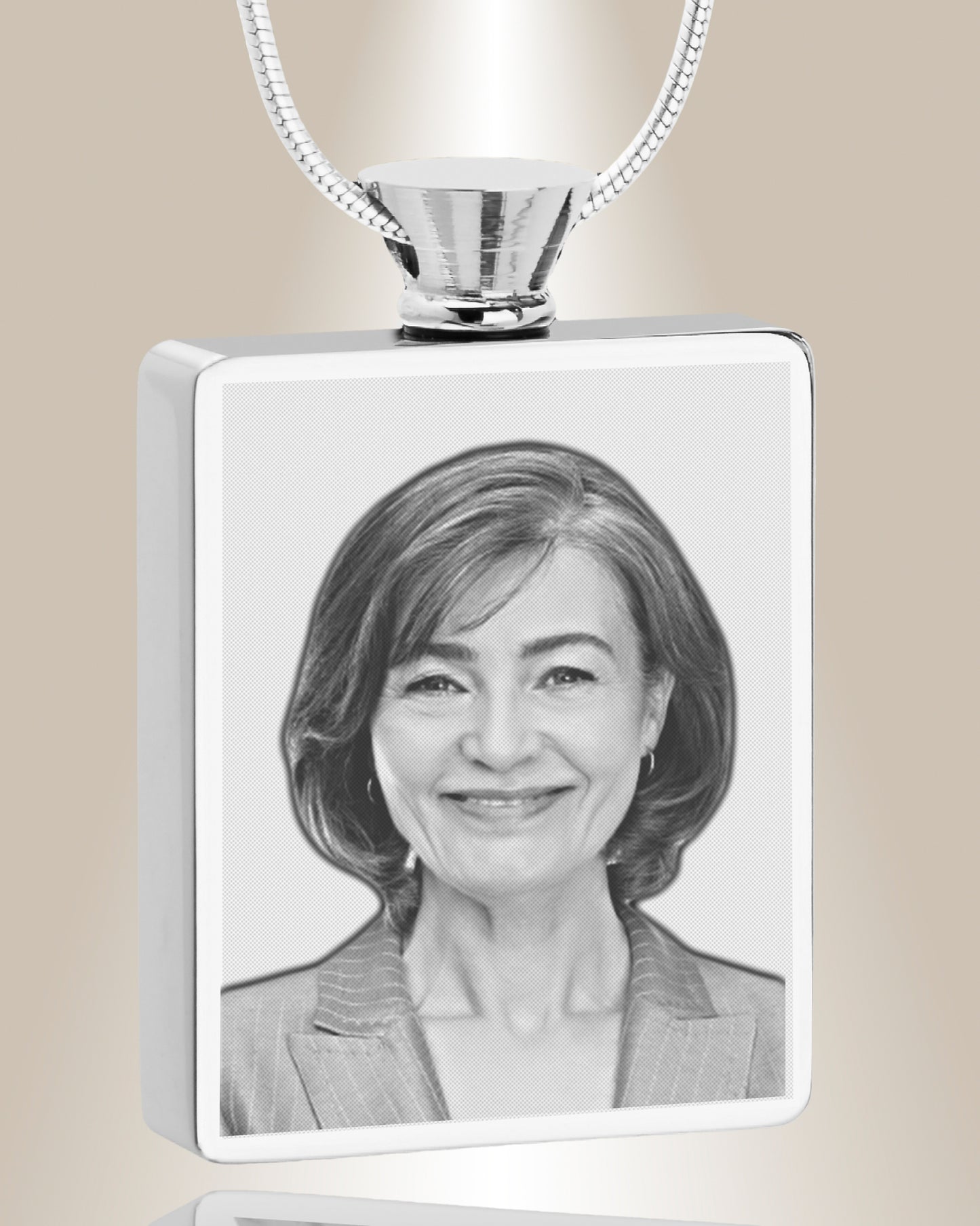 A stainless steel rectangle photo pendant with an engraved image of a woman, accompanied by a 20-inch chain.