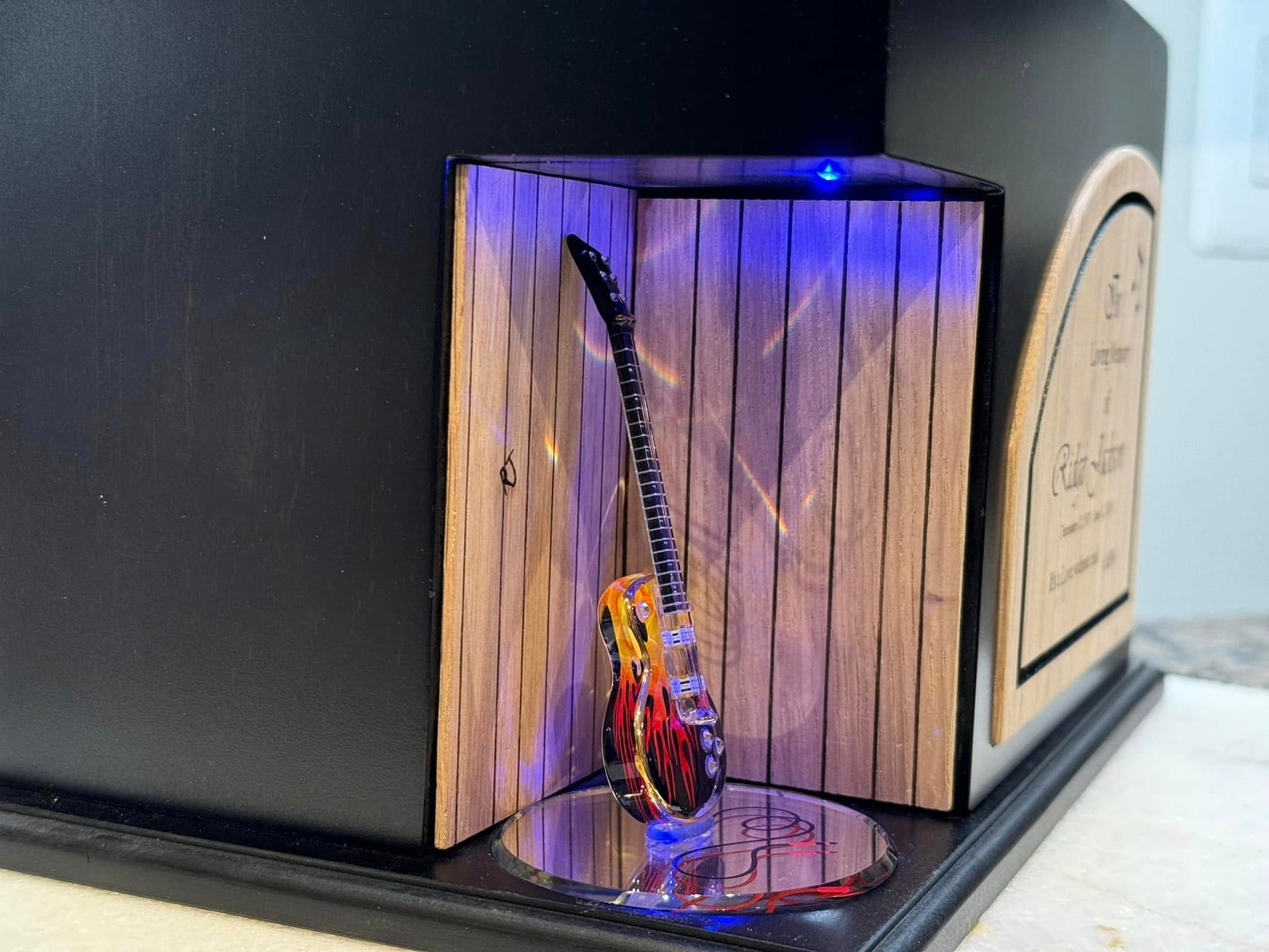side view of wood urn showcasing a lighted guitar for music lovers