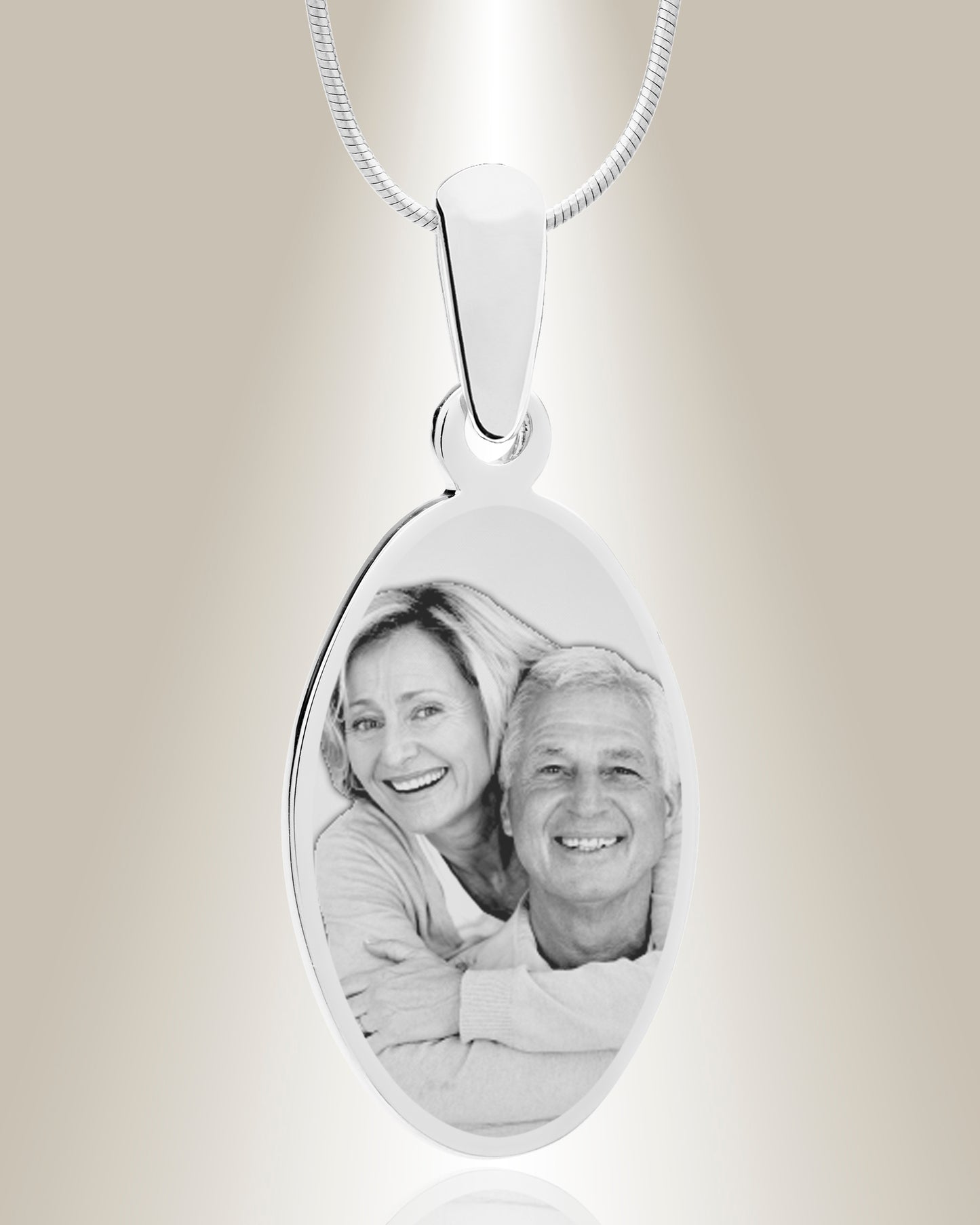An oval-shaped stainless steel pendant with an engraved photo of a smiling couple, attached to a 20-inch chain.