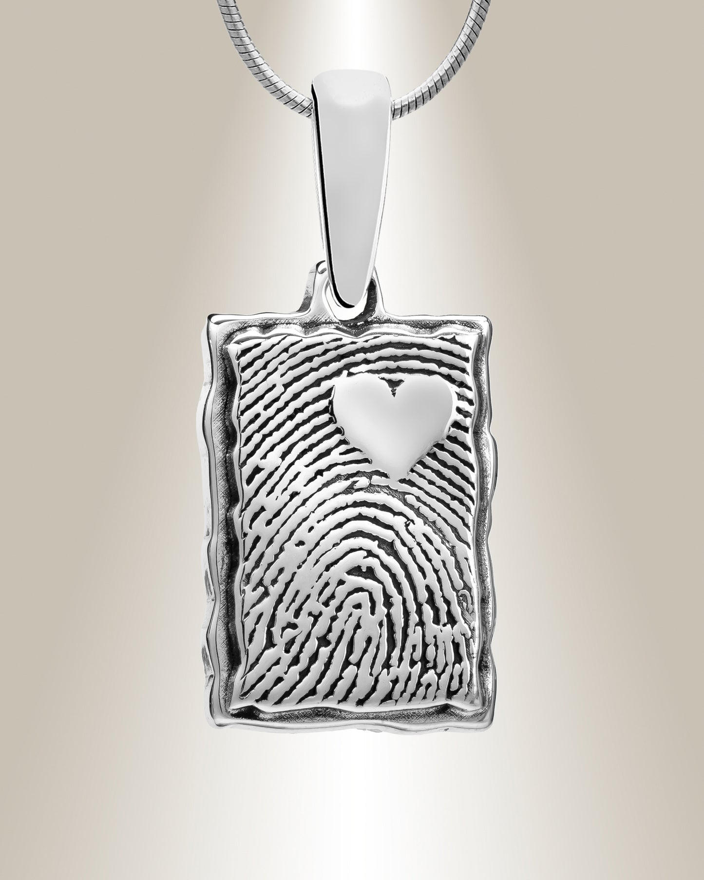 A sterling silver pendant with a rectangle shape featuring a heart-shaped fingerprint detail at the top right corner, displayed against a neutral background.