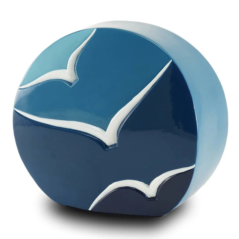 A ceramic urn with a glossy blue gradient finish featuring hand-painted contrasting birds in white. The urn has a unique, textured surface and appears spherical in shape.