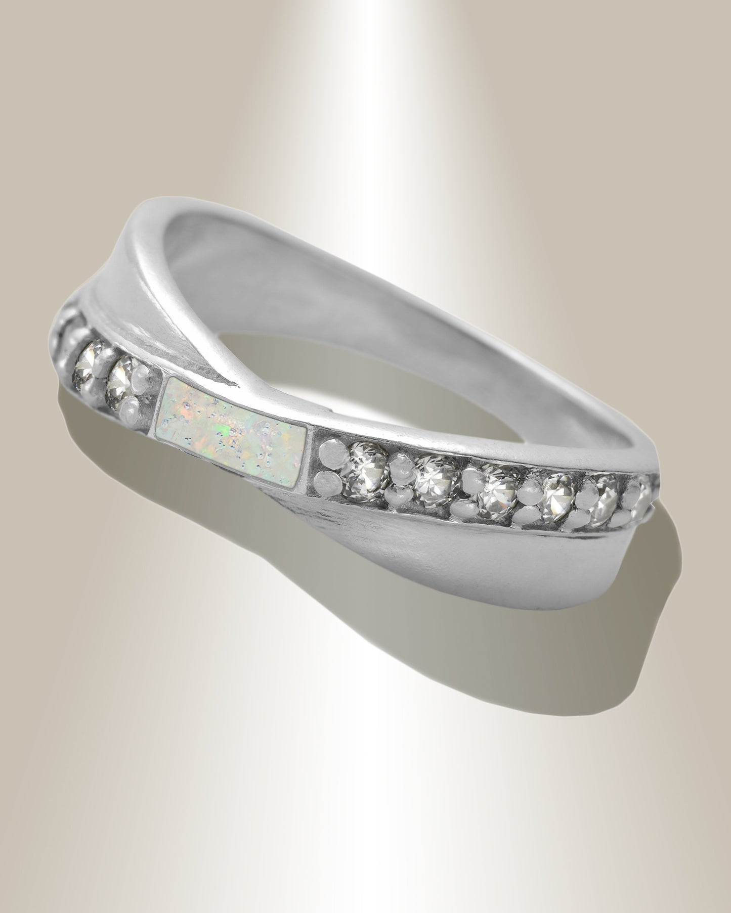 A women's ring for ashes featuring a clear band with small diamond-like accents, and a rectangle at the top center with ice opal colored resin, set against a neutral background.