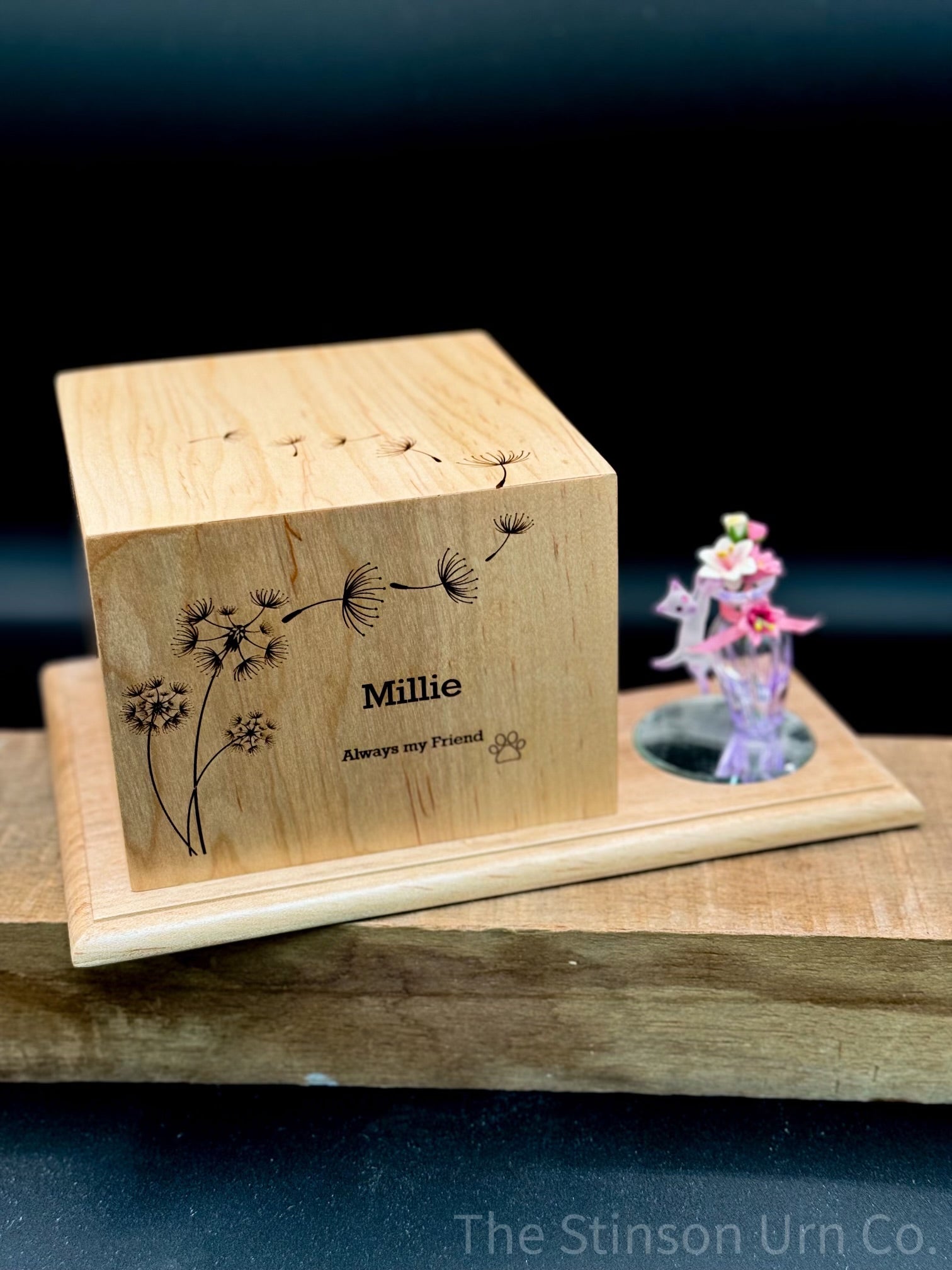 Whimsical Wood Pet Urn. This urn shows a cat paw and dandelions engraved on it. 