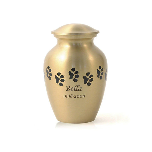 A bronze-toned brass cremation urn with paw print accents and a personalized engraving of a pet's name.