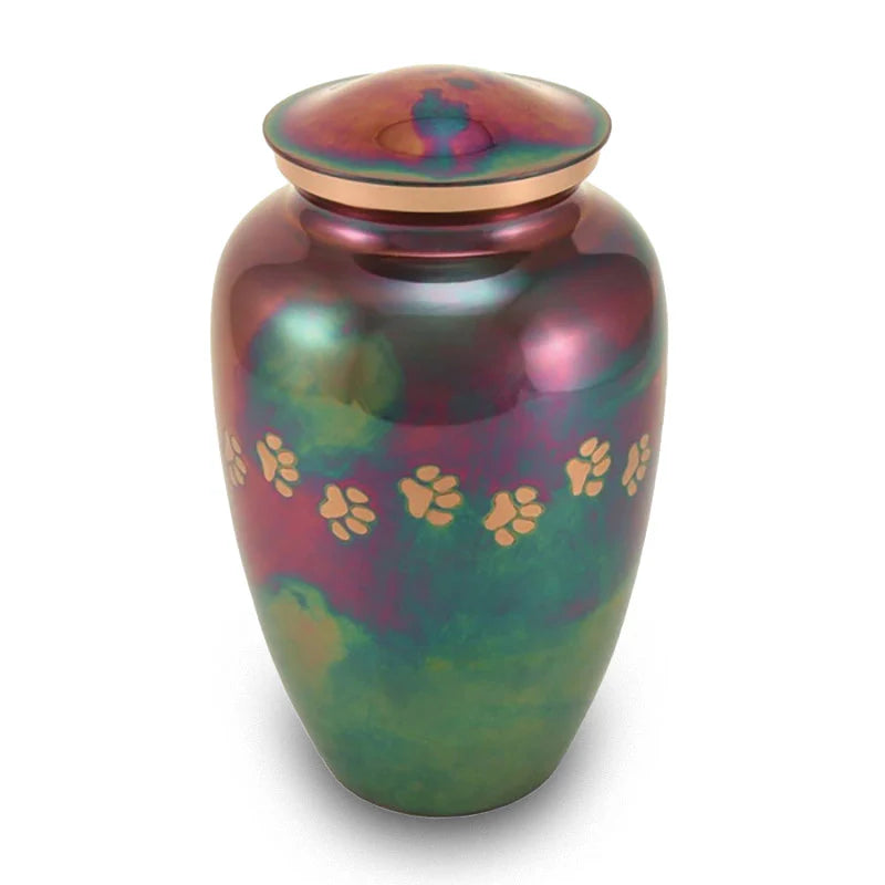 A multicolored brass cremation urn with paw print accents and a traditional shape, displayed against a white background.