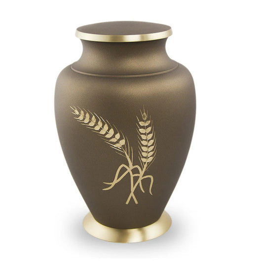 A bronze cremation urn with engraved golden wheat accents on the front, a threaded lid, and a mocha finish.