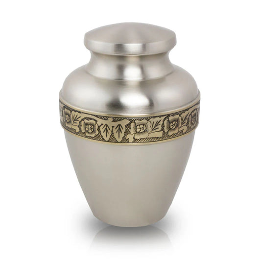 A brass cremation urn with a floral band accent, hand etched by artisans.