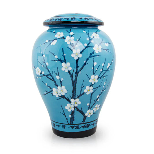 A ceramic cremation urn with a blue background and white floral patterns.