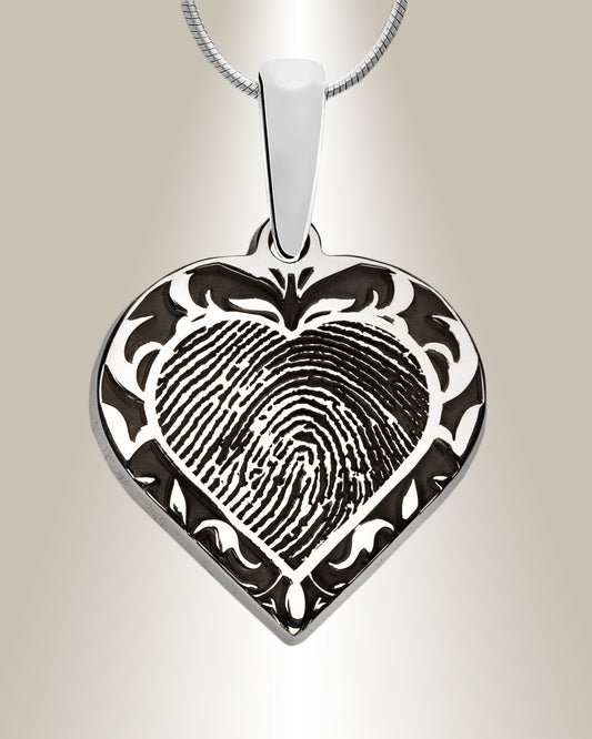 A sterling silver heart-shaped pendant with a filigree motif and a laser-engraved fingerprint in the center, accompanied by a 20-inch chain.