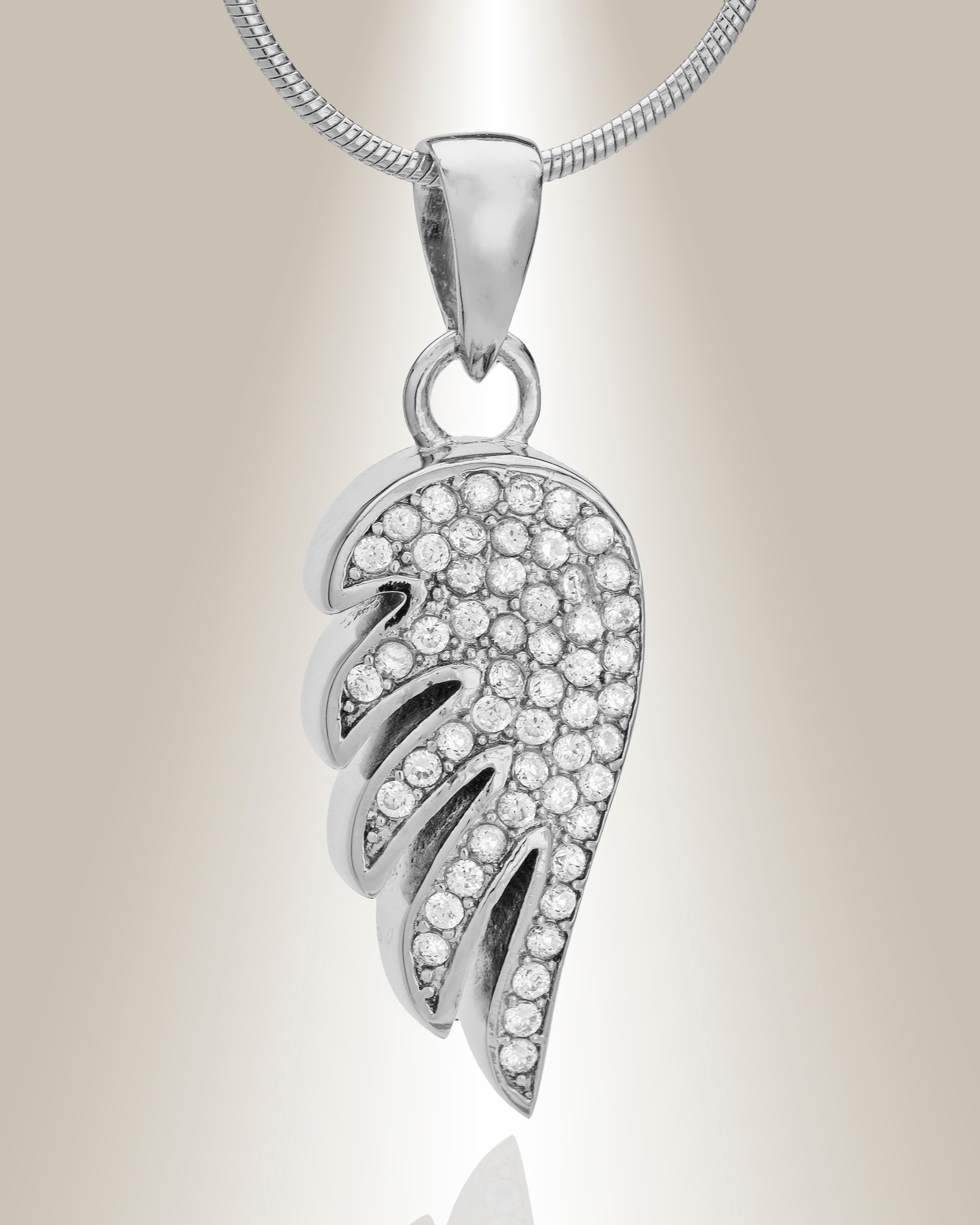 Angel wing shaped cremation pendant made of sterling silver with gemstone accents, displayed with an included matching 20