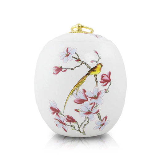 A white ceramic floral urn with hand-painted golden birds and floral motifs, featuring a copper plated ring handle on the lid.