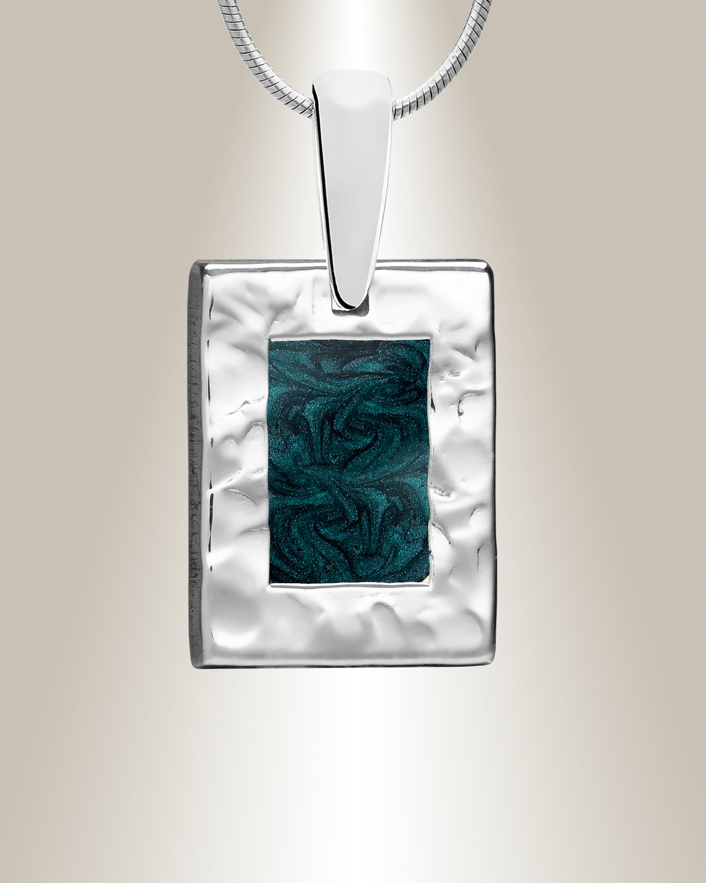 A silver rectangle-shaped pendant with a hammered finish and a blue resin inset, suspended from a silver chain.