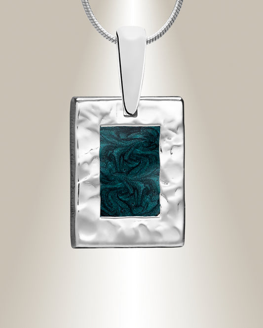 A silver rectangle-shaped pendant with a hammered finish and a blue resin inset, suspended from a silver chain.