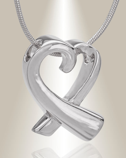 A silver heart-shaped cremation pendant with a butterfly motif on the top point, attached to a chain.