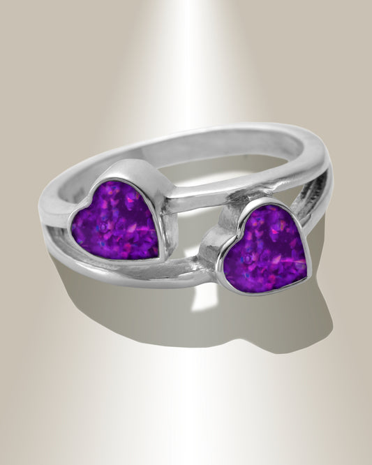 A sterling silver ring for ashes with two heart-shaped purple resin inserts at the top center.