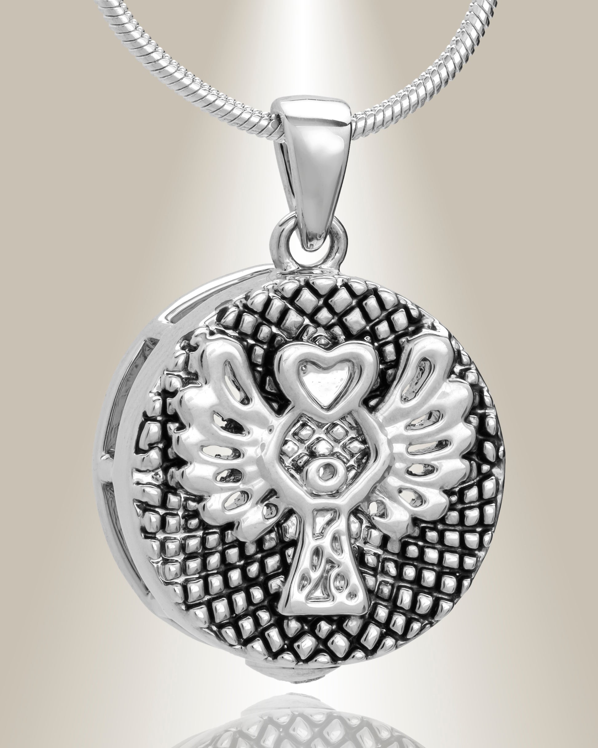 A sterling silver round cremation pendant with a weaved design and an angel motif, displayed with a 20" chain.