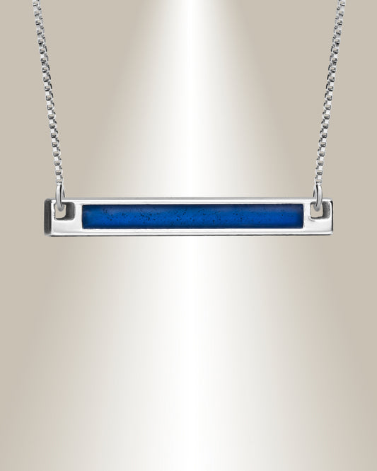 A horizontal bar pendant necklace with a blend of cremated ashes and resin, attached to a chain.