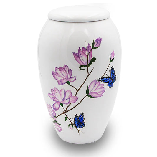 A white urn with a hand-crafted mother of pearl design featuring pink and blue butterflies and flowers.