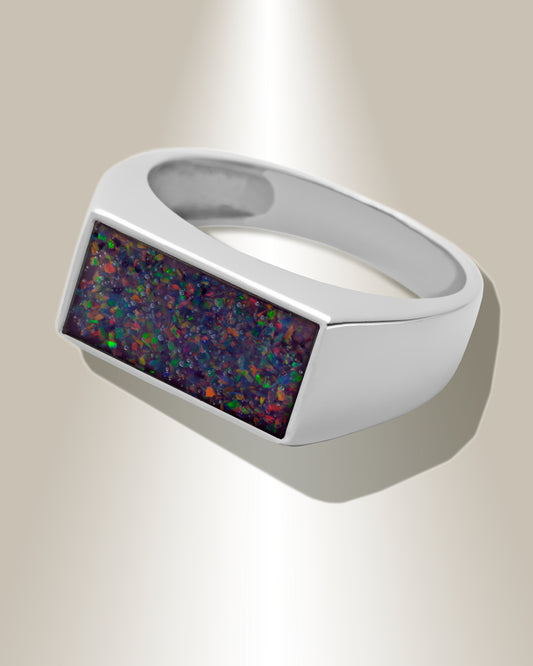 A men's wide ring with a rectangular ash infused resin insert at the top center, showcasing a multicolored pattern.