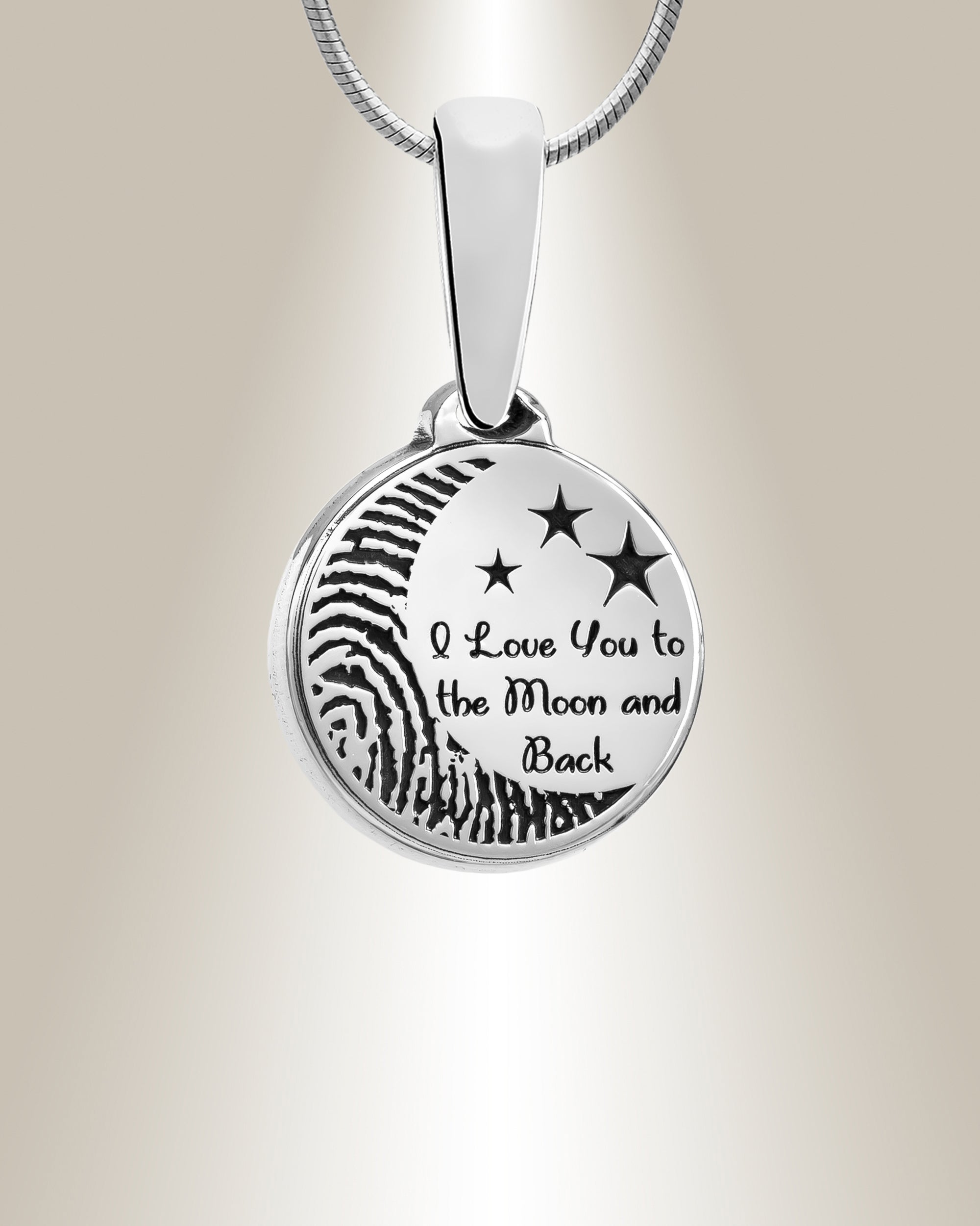 A sterling silver round pendant with an engraved fingerprint shape and the phrase 'I love you to the moon and back', accompanied by a matching 20