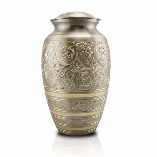 A large bronze cremation urn with a smooth black lacquer cover, hand etched with a floral filigree design.