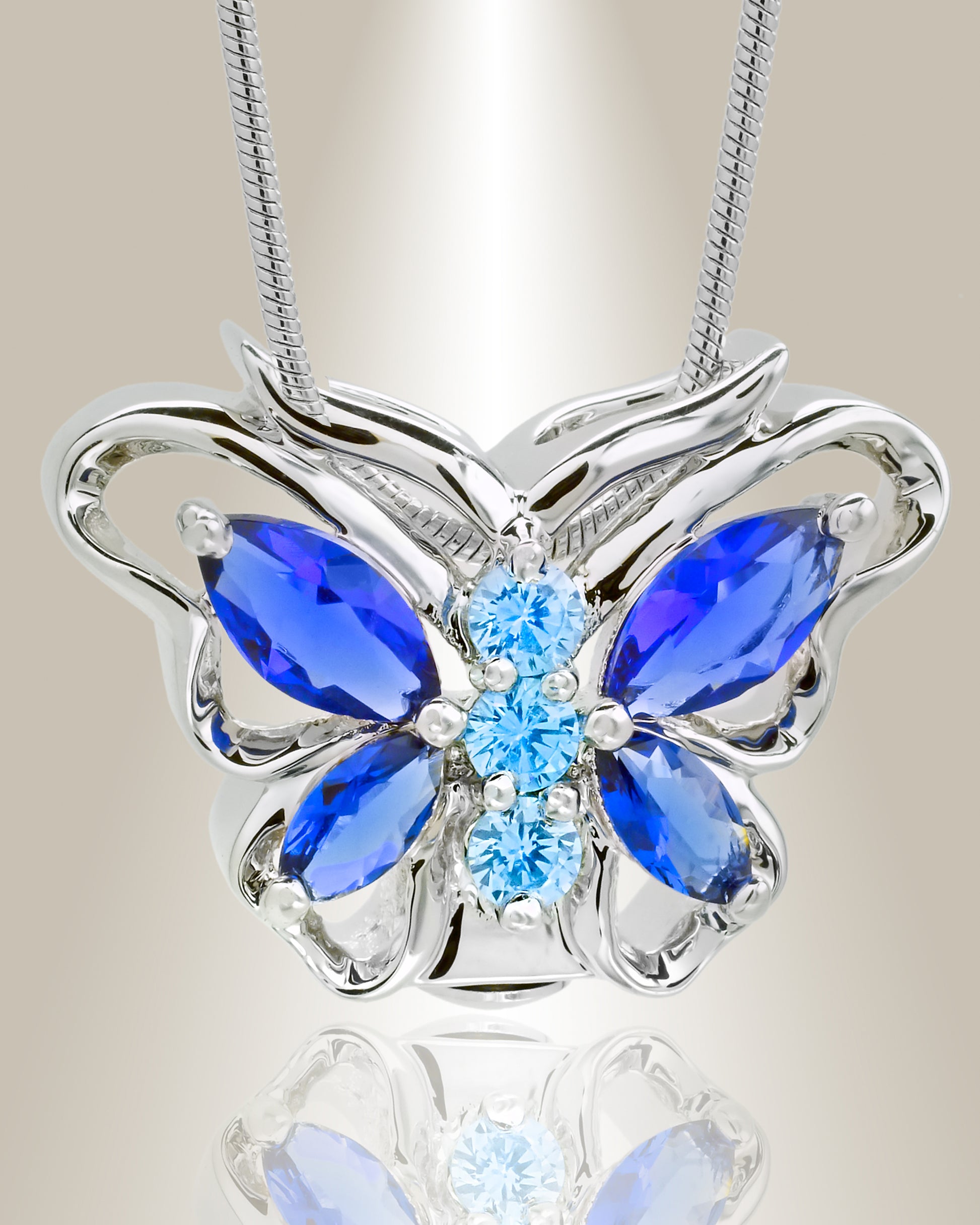 A silver butterfly-shaped cremation pendant with blue accent stones on a chain.