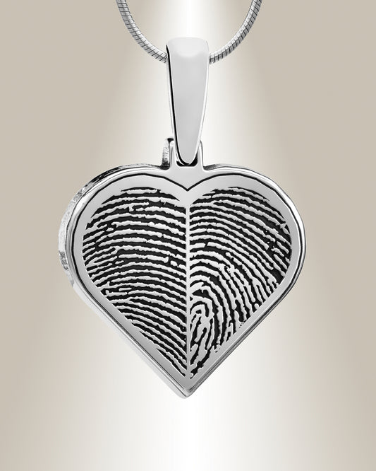 A silver heart-shaped pendant with a fingerprint engraved on the front, attached to a chain.
