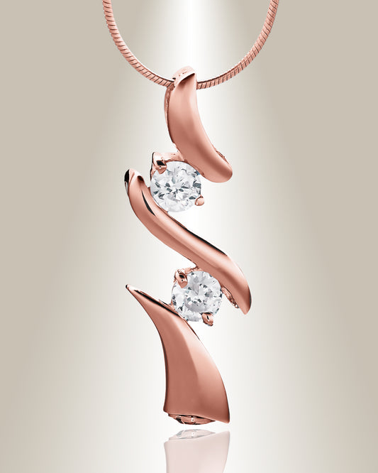 A rose gold trinity cremation pendant with two clear gemstone accents on a chain, designed to hold cremated ashes.