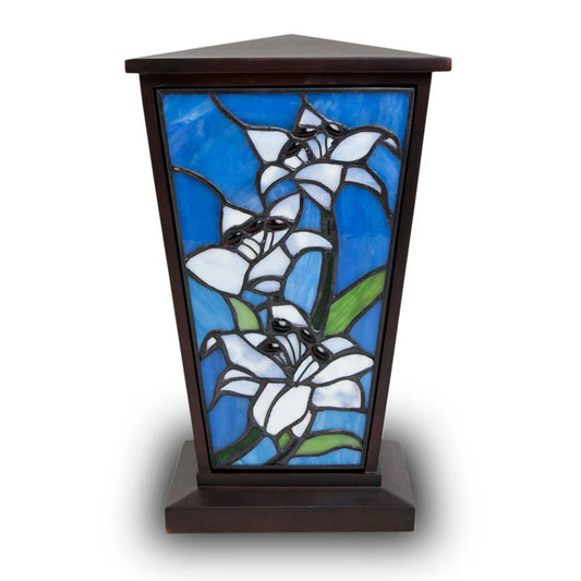 A handcrafted stained glass Easter lily design on a cremation urn.