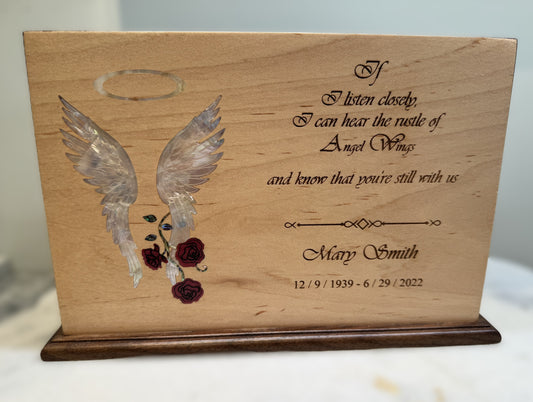 Custom two-tone wood urn featuring an intricate inlay of angel wings and roses, personalized for "Mary Smith".