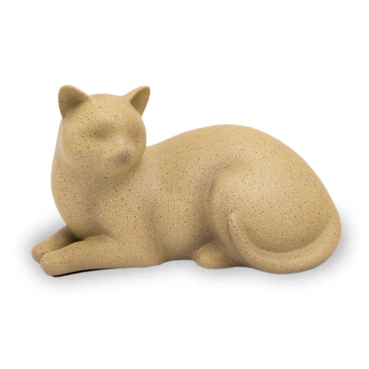 A handcrafted resin cat cremation urn in a warm tan fawn color, resembling a reclining cat.
