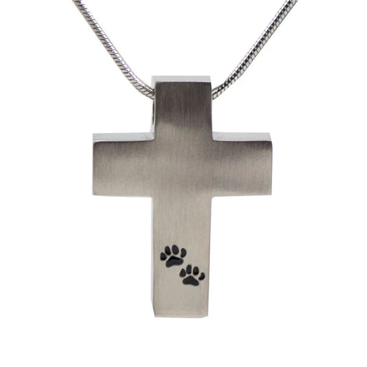 A stainless steel cross cremation pendant with two small paw prints engraved on the front, accompanied by an 18-inch pewter color snake chain.
