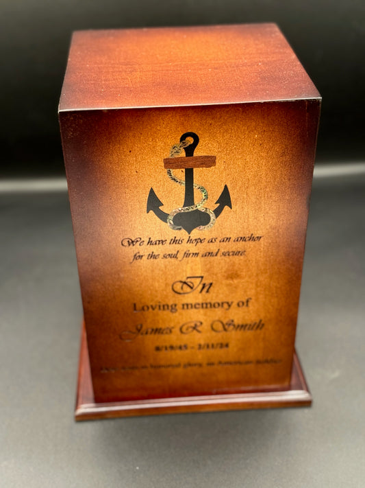 A wooden urn with an anchor design and rope detail, made from rich ebony wood and mother of pearl respectively.